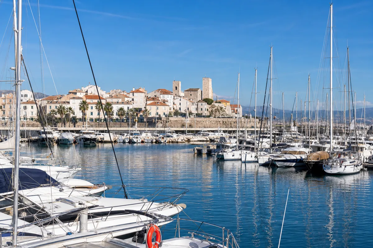 Port de plaisance avec voiliers et immeubles blancs sur la Côte d’Azur
